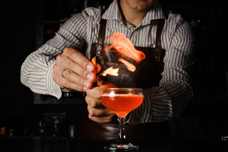 The Try Not To Light Yourself On Fire The bartender makes flame above cocktail. Mixologist, alcohol.