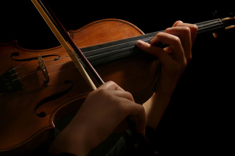 Violin is in the hands of professional violinist. Details of violin playing isolated on Violin is in the hands of professional violinist. Details of violin playing isolated on