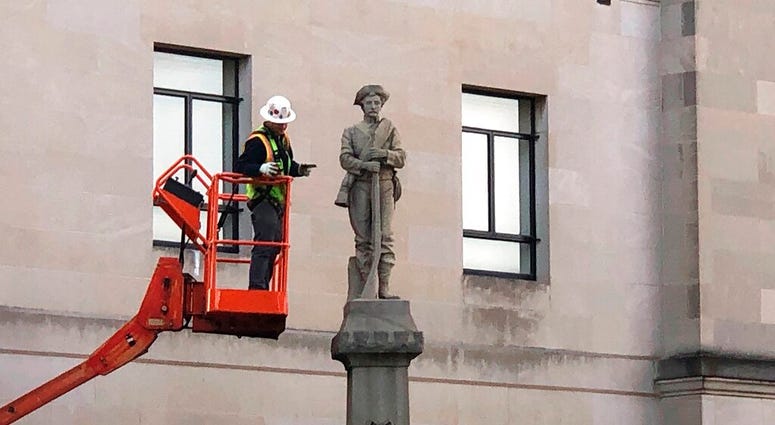 A workman prepares a Confederate staute for removal, Tuesday, March 12, 2019, in Winston-Salem, N.C. (AP Photo/Tom Foreman Jr.)