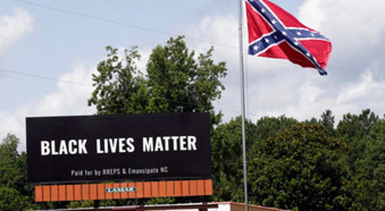 A Black Lives Matter billboard is seen next to a Confederate flag in Pittsboro, N.C., Thursday, July 16, 2020. A group in North Carolina erected the billboard to counter the flag that stands along the road. (AP Photo/Gerry Broome) A Black Lives Matter billboard is seen next to a Confederate flag in Pittsboro, N.C., Thursday, July 16, 2020. A group in North Carolina erected the billboard to counter the flag that stands along the road. (AP Photo/Gerry Broome)