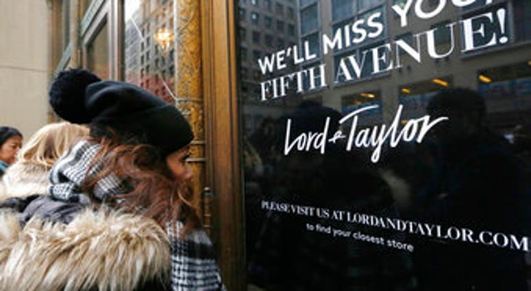 FILE - In this Jan. 2, 2019, file photo, women peer in the front door of Lord & Taylor's flagship Fifth Avenue store which closed for good in New York. (AP Photo/Kathy Willens, File) FILE - In this Jan. 2, 2019, file photo, women peer in the front door of Lord & Taylor's flagship Fifth Avenue store which closed for good in New York. (AP Photo/Kathy Willens, File)