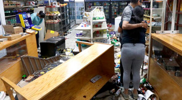Yogi Dalal hugs his daughter Jigisha as his other daughter Kajal, left, bows her head at the family food and liquor store Monday, Aug. 10, 2020, after the family business was vandalized in Chicago. (AP Photo/Charles Rex Arbogast) Yogi Dalal hugs his daughter Jigisha as his other daughter Kajal, left, bows her head at the family food and liquor store Monday, Aug. 10, 2020, after the family business was vandalized in Chicago. (AP Photo/Charles Rex Arbogast)