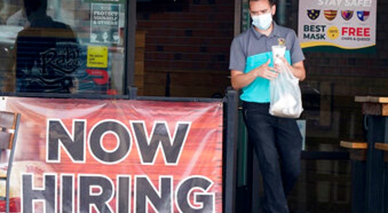 FILE - In this Sept. 2, 2020 file photo, a customer wears a face mask as they carry their order past a now hiring sign at an eatery in Richardson, Texas. (AP Photo/LM Otero, File) FILE - In this Sept. 2, 2020 file photo, a customer wears a face mask as they carry their order past a now hiring sign at an eatery in Richardson, Texas. (AP Photo/LM Otero, File)