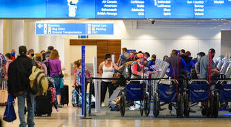 Holiday travelers check in at kiosks near an airline counter at Orlando International Airport Tuesday, Nov. 24, 2020, in Orlando, Fla. (AP Photo/John Raoux) Holiday travelers check in at kiosks near an airline counter at Orlando International Airport Tuesday, Nov. 24, 2020, in Orlando, Fla. (AP Photo/John Raoux)