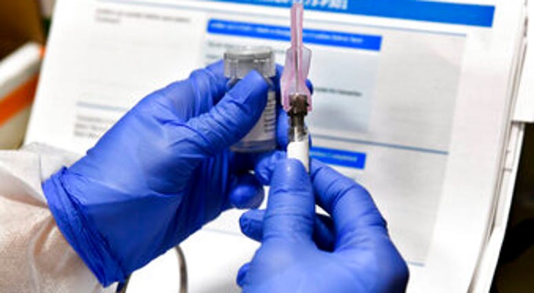 FILE - In this July 27, 2020, file photo, nurse Kathe Olmstead prepares a shot that is part of a possible COVID-19 vaccine, developed by the National Institutes of Health and Moderna Inc., in Binghamton, N.Y. (AP Photo/Hans Pennink, File) FILE - In this July 27, 2020, file photo, nurse Kathe Olmstead prepares a shot that is part of a possible COVID-19 vaccine, developed by the National Institutes of Health and Moderna Inc., in Binghamton, N.Y. (AP Photo/Hans Pennink, File)