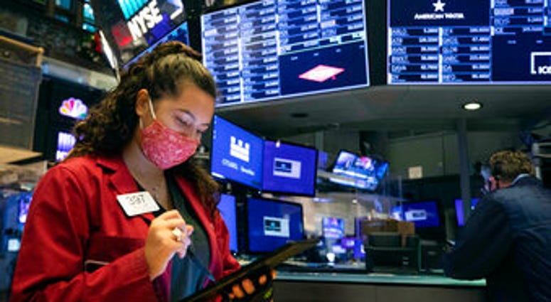 In this photo provided by the New York Stock Exchange, trader Ashley Lara uses her handheld device as she works on the trading floor, Tuesday, Dec. 1, 2020. (Colin Ziemer/New York Stock Exchange via AP) In this photo provided by the New York Stock Exchange, trader Ashley Lara uses her handheld device as she works on the trading floor, Tuesday, Dec. 1, 2020. (Colin Ziemer/New York Stock Exchange via AP)
