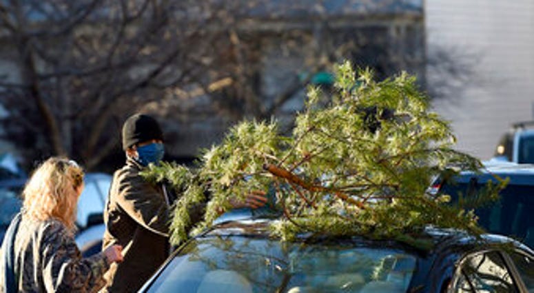 Parker Vivier and Marsden Olsen, both of Richmond, prepare to tie their tree to their car after purchasing from Frank Pichel's tree lot, Sunday, Dec. 6, 2020, in Richmond. (AP Photo/Will Newton) Parker Vivier and Marsden Olsen, both of Richmond, prepare to tie their tree to their car after purchasing from Frank Pichel's tree lot, Sunday, Dec. 6, 2020, in Richmond. (AP Photo/Will Newton)