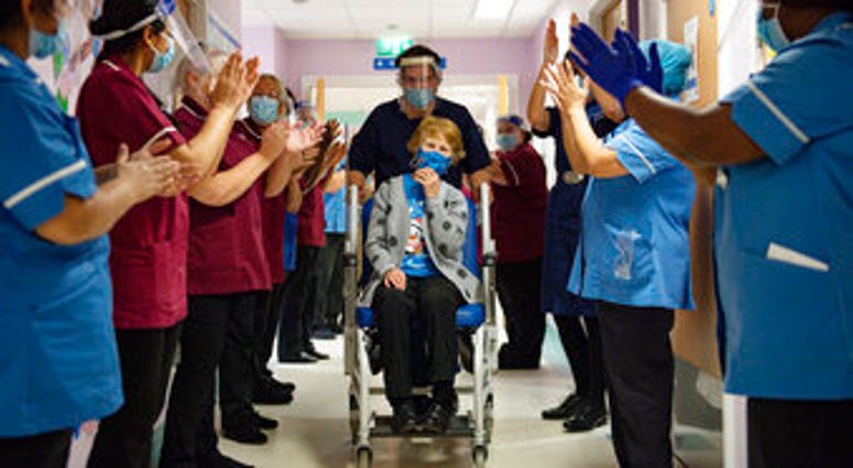 Margaret Keenan, 90, is applauded by staff as she returns to her ward after becoming the first patient in the UK to receive the Pfizer-BioNTech COVID-19 vaccine. (Jacob King/Pool via AP) Margaret Keenan, 90, is applauded by staff as she returns to her ward after becoming the first patient in the UK to receive the Pfizer-BioNTech COVID-19 vaccine. (Jacob King/Pool via AP)