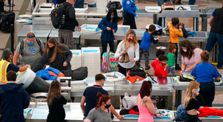 Travelers wear face masks while passing through the south security checkpoint in the main terminal of Denver International Airport Tuesday, Dec. 22, 2020, in Denver. (AP Photo/David Zalubowski) Airport Tuesday, Dec. 22, 2020, in Denver. (AP Photo/David Zalubowski)
