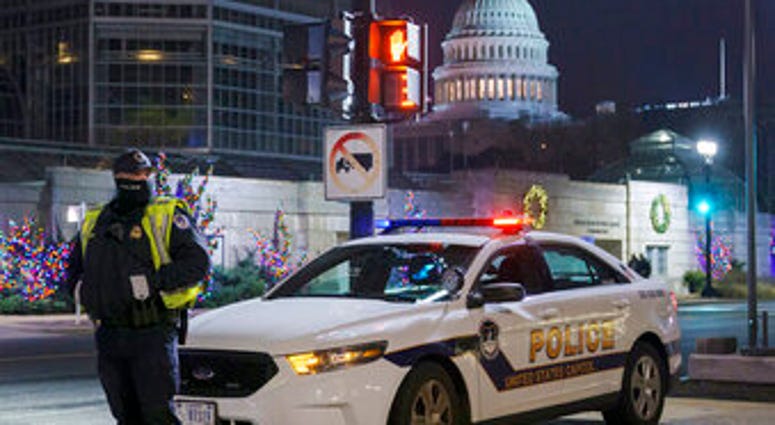 A U.S. Capitol Police officer stands watch on Independence Avenue before dawn as the House and Senate prepare to convene a joint session to count the electoral votes cast in November's election. (AP Photo/J. Scott Applewhite) A U.S. Capitol Police officer stands watch on Independence Avenue before dawn as the House and Senate prepare to convene a joint session to count the electoral votes cast in November's election. (AP Photo/J. Scott Applewhite)