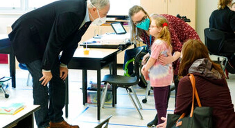 Washington Gov. Jay Inslee, left, talks with a student as teacher Alyson Lykken, center, looks on, Tuesday, Feb. 2, 2021, during a visit to a low-incidence disability classroom at Elk Ridge Elementary School in Buckley, Wash. (AP Photo/Ted S. Warren) Washington Gov. Jay Inslee, left, talks with a student as teacher Alyson Lykken, center, looks on, Tuesday, Feb. 2, 2021, during a visit to a low-incidence disability classroom at Elk Ridge Elementary School in Buckley, Wash. (AP Photo/Ted S. Warren)