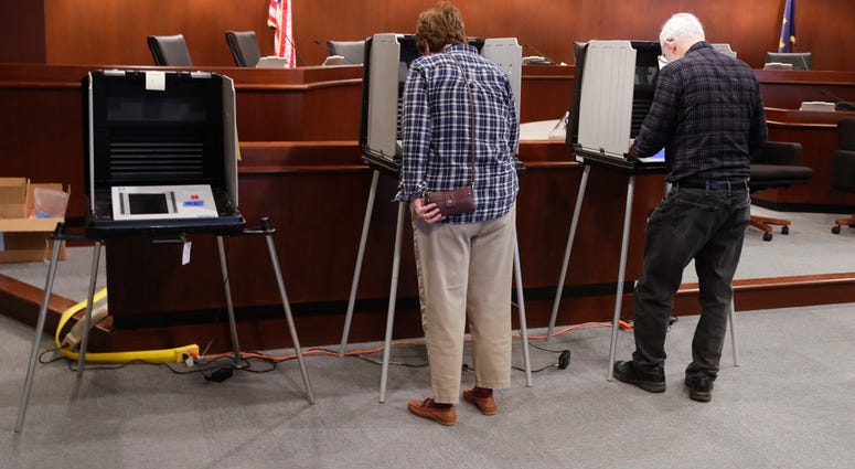 In this Friday, April 27, 2018 photo, voters prepare their ballots during early voting at the Hamilton County Government Center in Noblesville, Ind. (AP Photo/Michael Conroy)