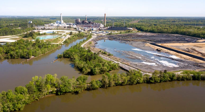 The Richmond city skyline can be seen on the horizon behind the coal ash ponds along the James River near Dominion Energy's Chesterfield Power Station in Chester, Va. (AP Photo/Steve Helber)