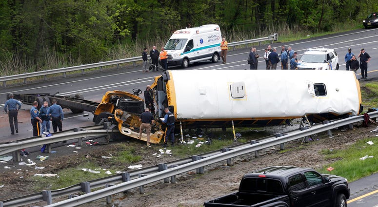 Emergency personnel work at the scene of a school bus and dump truck collision, injuring multiple people, on Interstate 80 in Mount Olive, N.J., Thursday, May 17, 2018. (AP Photo/Seth Wenig)