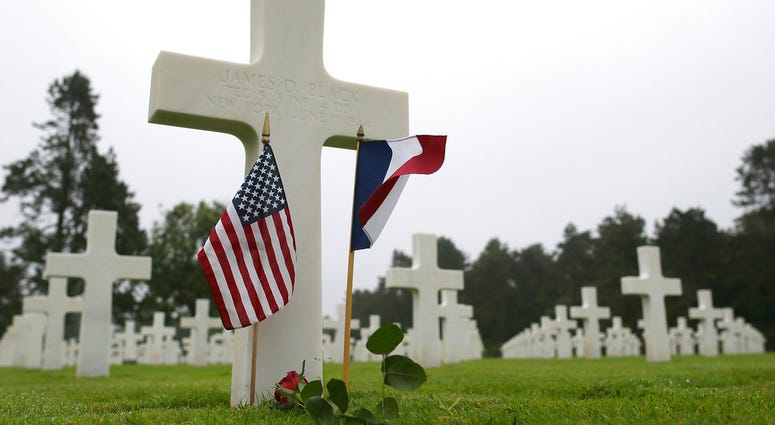 US and French flags and a flower are placed on the grave ofJames D. Black, from New York, who died on June 11, 1944, at the Colleville American military cemetery, in Colleville sur Mer, western France, Wednesday June 6, 2018, on the 74th anniversary of th