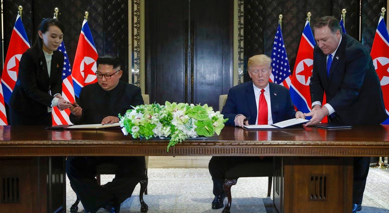 North Korea leader Kim Jong Un and U.S. President Donald Trump prepare to sign a document at the Capella resort on Sentosa Island Tuesday, June 12, 2018 in Singapore. (AP Photo/Evan Vucci)