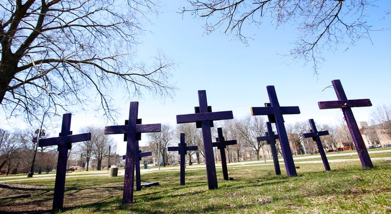 FILE - In this Thursday, April 19, 2018 file photo, crosses representing victims of gun violence stand outside Collins Academy High School in Chicago's North Lawndale neighborhood. With frustration mounting over lawmakers' inaction on gun control, the Ame
