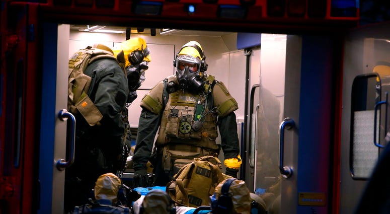 German police officers in protective gear enters a rescue car during an operation in Cologne, Germany, late Tuesday June 12, 2018. German police are searching the apartment of a 29-year-old Tunisian man who is accused of keeping toxic substances in his ho
