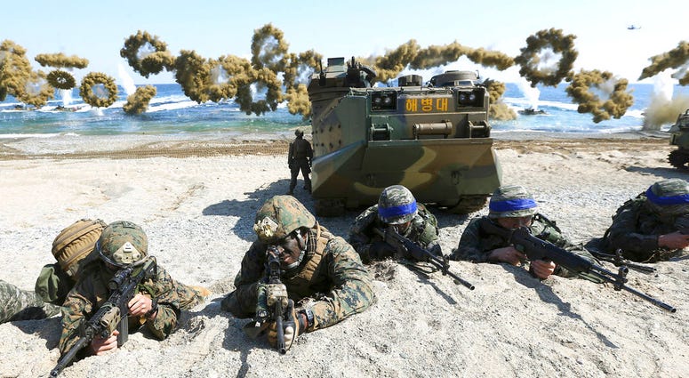 FILE - In this March 12, 2016, file photo, Marines of the U.S., left, and South Korea wearing blue headbands on their helmets, take positions after landing on a beach during the joint military combined amphibious exercise, called Ssangyong, part of the Ke