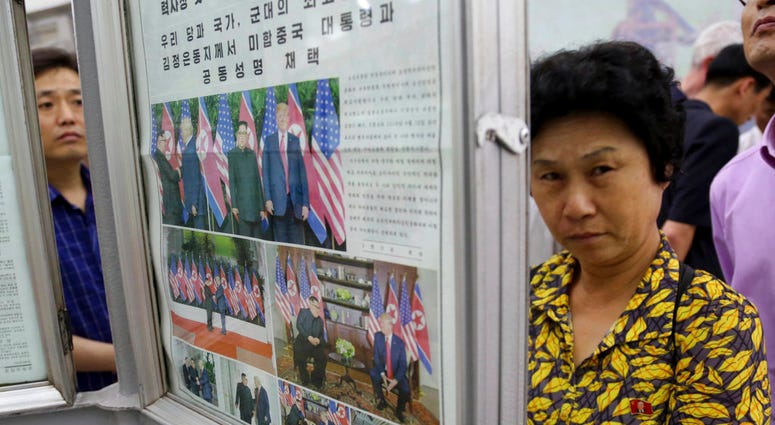 In this Wednesday, June 13, 2018, photo, people read a newspaper dominated with news on the summit between U.S. President Donald Trump and North Korean leader Kim Jong Un at a subway station in Pyongyang, North Korea. North Koreans are getting a new look