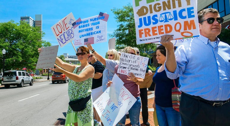 People line up to protest U.S. Attorney General Jeff Sessions and immigration reform at Parkview Field in Fort Wayne, Ind. Thursday, June 14, 2018. (Mike Moore/The Journal-Gazette via AP)