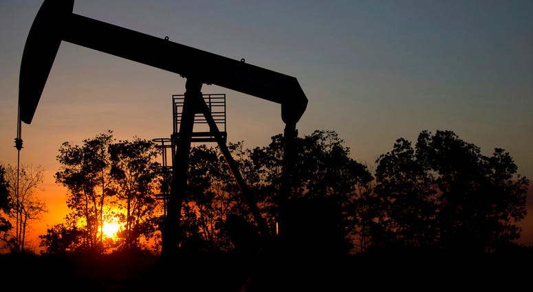In this Feb. 19, 2015, file photo, the sun sets behind an oil well in a field near El Tigre, Venezuela. (AP Photo/Fernando Llano, File)