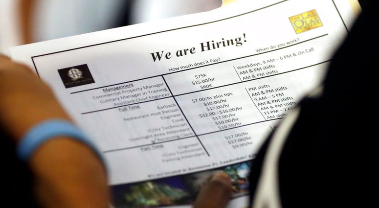In this Thursday, June 21, 2018 photo, a job applicant looks at job listings for the Riverside Hotel at a job fair hosted by Job News South Florida, in Sunrise, Fla. The Labor Department said Friday, July 6, that the unemployment rate rose to 4.0 percent