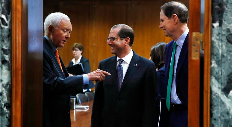 Senate Finance Committee chair Sen. Orrin Hatch, R-Utah, left, and ranking member Sen. Ron Wyden, D-Ore., right, speak with Health and Human Services Secretary Alex Azar before a hearing on prescription drug pricing, Tuesday, June 26, 2018, on Capitol Hil