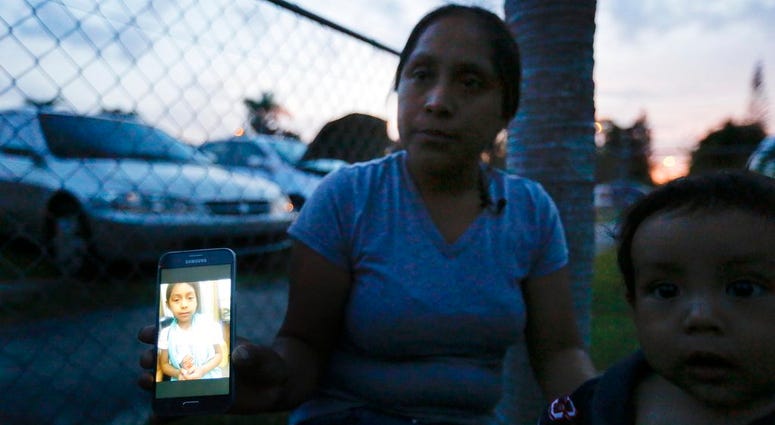 Buena Ventura Martin-Godinez, from Guatemala, shows a photograph of her daughter, Janne, on her phone during an interview with the Associated Press outside her home in Homestead, Fla., on Wednesday, June 27, 2018. (AP Photo/Brynn Anderson)