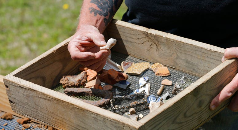 In this April 10, 2018 photo, a Jamestown Rediscovery Foundation archeologist shows artifacts and discusses what they know about one of the first enslaved Africans to live in English North America in Jamestown, Va.(AP Photo/Steve Helber) In this April 10, 2018 photo, a Jamestown Rediscovery Foundation archeologist shows artifacts and discusses what they know about one of the first enslaved Africans to live in English North America in Jamestown, Va.(AP Photo/Steve Helber)