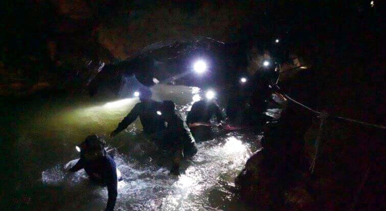 n this handout photo released by Tham Luang Rescue Operation Center, Thai rescue teams walk inside cave complex where 12 boys and their soccer coach went missing, in Mae Sai, Chiang Rai province, in northern Thailand, Monday, July 2, 2018. Rescue divers a