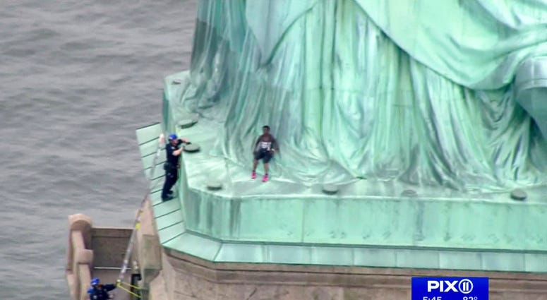 Woman climbs on Statue of Liberty