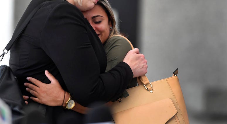 Sirley Silveira Paixao an immigrant from Brazil seeking asylum, hugs her Chicago based attorney after a hearing, Thursday, July 5, 2018. (AP Photo/Annie Rice)
