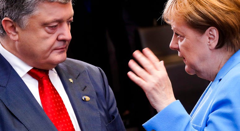 German Chancellor Angela Merkel, right, and Ukraine's President Petro Poroshenko, left, talk together at NATO headquarters in Brussels on Thursday, July 12, 2018. (AP Photo/Markus Schreiber)