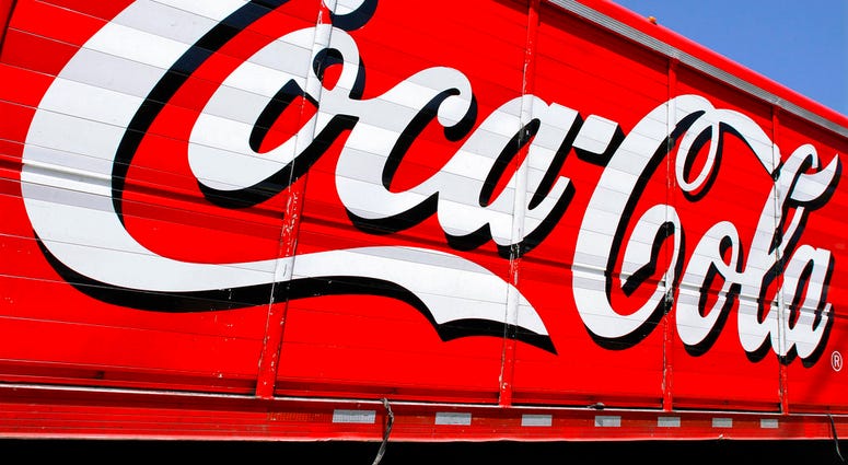 This June 25, 2012 file photo shows the Coca-Cola logo on the side of a delivery truck in Springfield, Ill. Coca-Cola says it's buying a minority ownership stake in sports drink maker BodyArmor for an undisclosed amount