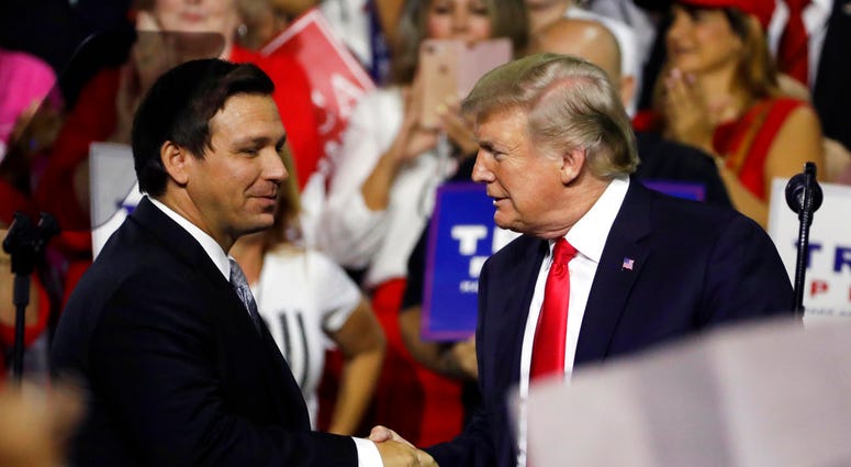 FILE - In this July 31, 2018, file photo, President Donald Trump, right, shakes hands with Florida Republican gubernatorial candidate Ron DeSantis during a rally in Tampa, Fla.(AP Photo/Chris O'Meara, File) FILE - In this July 31, 2018, file photo, President Donald Trump, right, shakes hands with Florida Republican gubernatorial candidate Ron DeSantis during a rally in Tampa, Fla.(AP Photo/Chris O'Meara, File)
