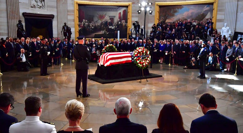The flag-draped casket of Sen. John McCain, R-Ariz., lies in state at the U.S. Capitol, Friday, August 31, 2018 in Washington. Seated third from left is Cindy McCain and Vice President Mike Pence to her right.