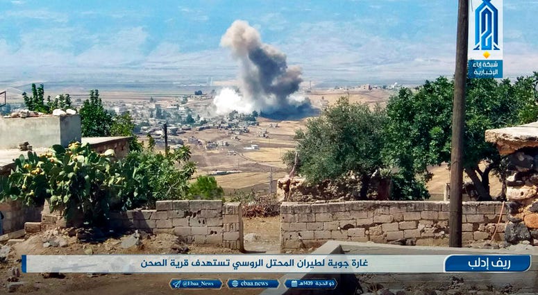 This photo released Tuesday, Sept 4, 2018 by the al-Qaida-affiliated Ibaa News Agency, shows smoke rising over buildings that were hit by airstrikes, in al-Sahan village, in the northern province of Idlib,