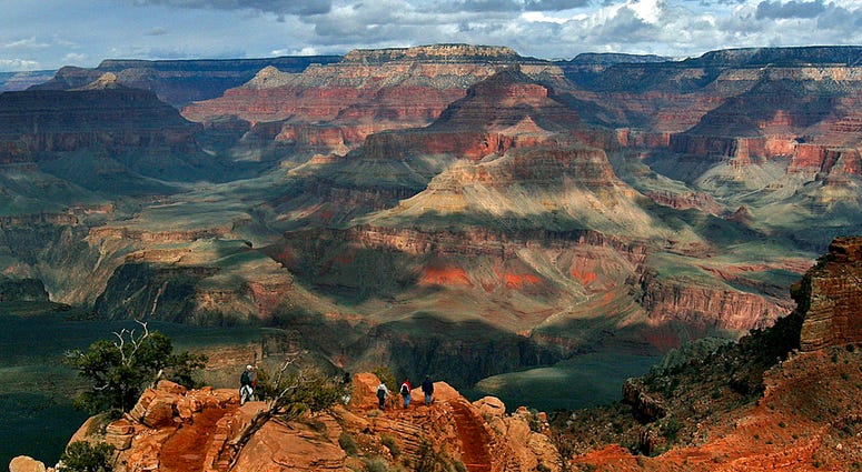 This Feb. 22, 2005 file photo shows the North Rim of the Grand Canyon, background, as tourists hike along the South Rim in Grand Canyon, Az