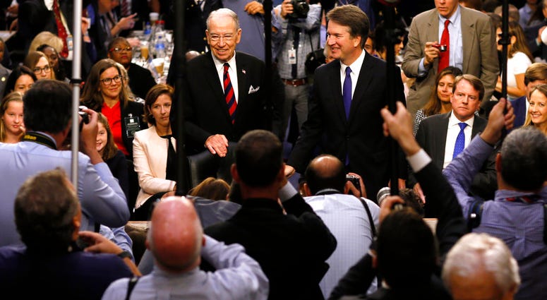 In this Sept. 4, 2018, file photo Supreme Court nominee Judge Brett Kavanaugh is surrounded by photographers as he stands with Senate Judiciary Committee Chairman Chuck Grassley R-Iowa