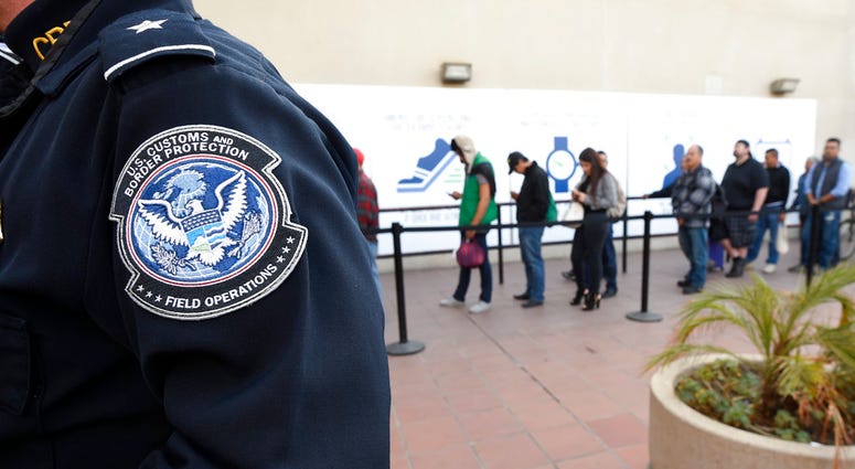 In this Dec. 10, 2015, file photo, pedestrians crossing from Mexico into the United States at the Otay Mesa Port of Entry wait in line in San Diego.