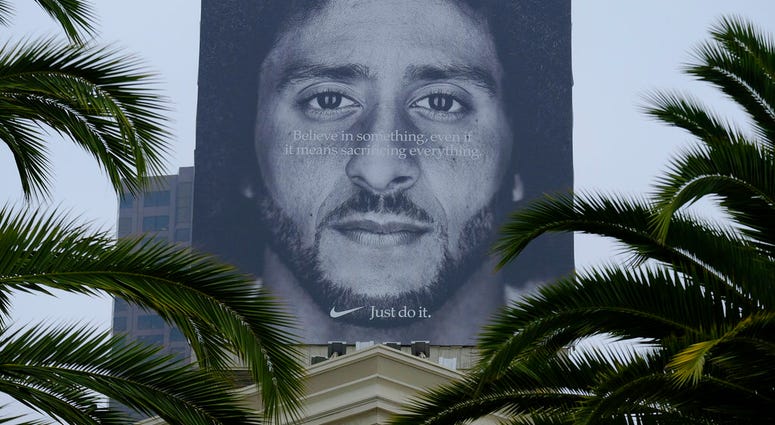In this Sept. 5, 2018, file photo palm trees frame a large billboard on top of a Nike store that shows former San Francisco 49ers quarterback Colin Kaepernick at Union Square in San Francisco. Nike Inc. reports earnings Tuesday, Sept. 25.
