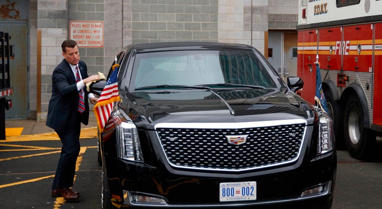 A Secret Service agent cleans the presidential limo before the arrival of Marine One carrying President Donald Trump at the Downtown Manhattan Heliport