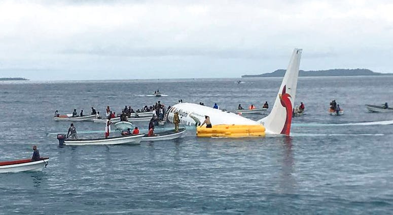 In this Sept. 28, 2018, file photo, local fishing boats move in to recover the passengers and crew of Air Niugini flight following the plane crashing into the sea on its approach to Chuuk International Airport in the Federated States of Micronesia.