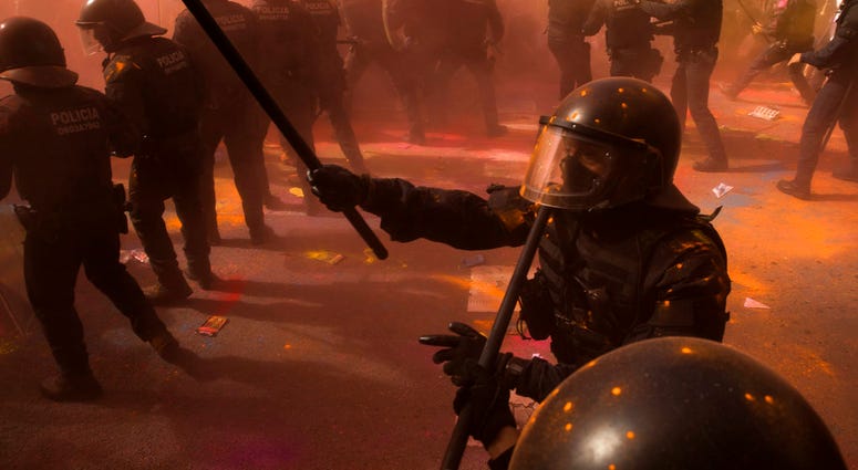 Catalan police officers clash with pro independence demonstrators in Barcelona on Saturday, Sept. 29,