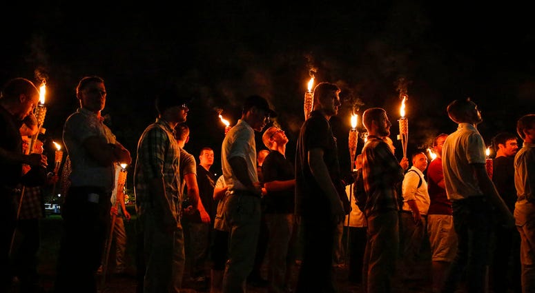 In this Aug. 11, 2017, file photo, multiple white nationalist groups march with torches through the University of Virginia campus in Charlottesville, Va. (Mykal McEldowney/The Indianapolis Star via AP, File)