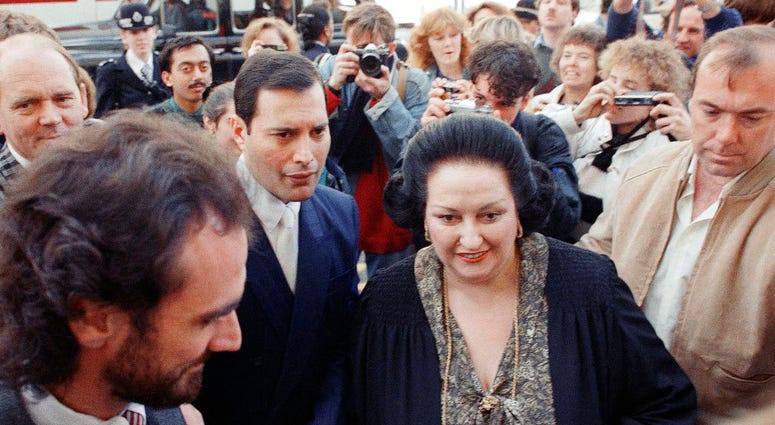In this Monday, Oct. 10, 1988 file photo, rock star Freddie Mercury, center left, lead singer of the pop group Queen, arrives with opera star Montserrat Caballe at the Royal Albert Hall in London to publicize their hit song 'Barcelona.'