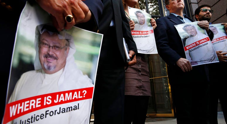 Alyssa Edling, center, and Thomas Malia, second from right, both with PEN America, join others as they hold signs of missing journalist Jamal Khashoggi, during a news conference about his disappearance in Washington. (AP Photo/Jacquelyn Martin)