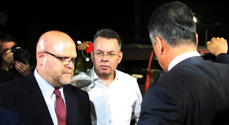 Pastor Andrew Brunson, center, and U.S. Charge d'Affaires Jeffrey Hovenier, left, arrive at Adnan Menderes airport