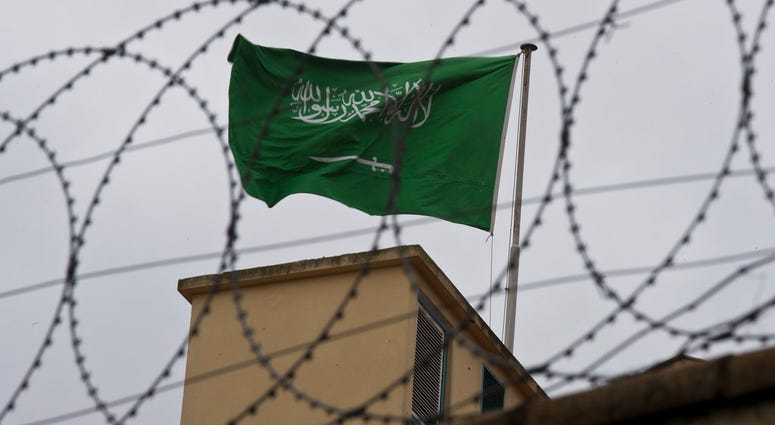 A flag of Saudi Arabia flies behind barb wire, on the roof top of Saudi Arabia's consulate in Istanbul, Saturday, Oct. 13, 2018.